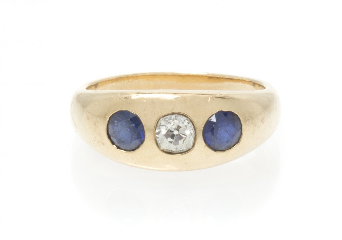 A Vintage 14 Karat Yellow Gold, Diamond and Sapphire Ri: A Vintage 14 Karat Yellow Gold, Diamond and Sapphire Ring, containing one old mine cut diamond weighing approximately 0.28 carat and two round brilliant cut sapphires. Stamp: 14K. 4.60 dwts.