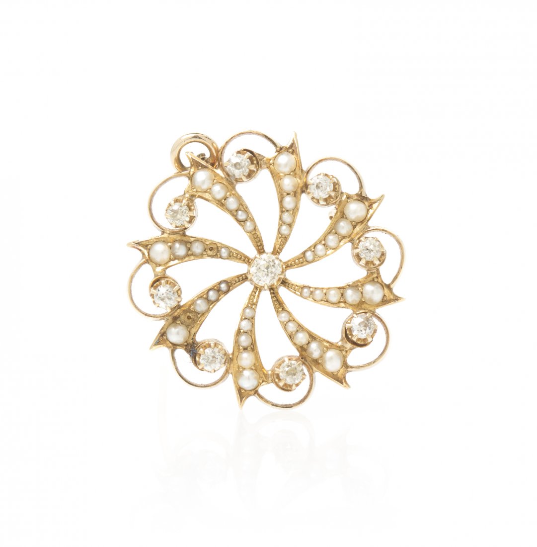 A 14 Karat Yellow Gold, Pearl and Diamond Starburst Pen: A 14 Karat Yellow Gold, Pearl and Diamond Starburst Pendant/ Brooch, containing nine old mine cut diamonds weighing approximately 0.69 carat total and numerous seed pearls. Stamp: 14K. 4.20 dwts.