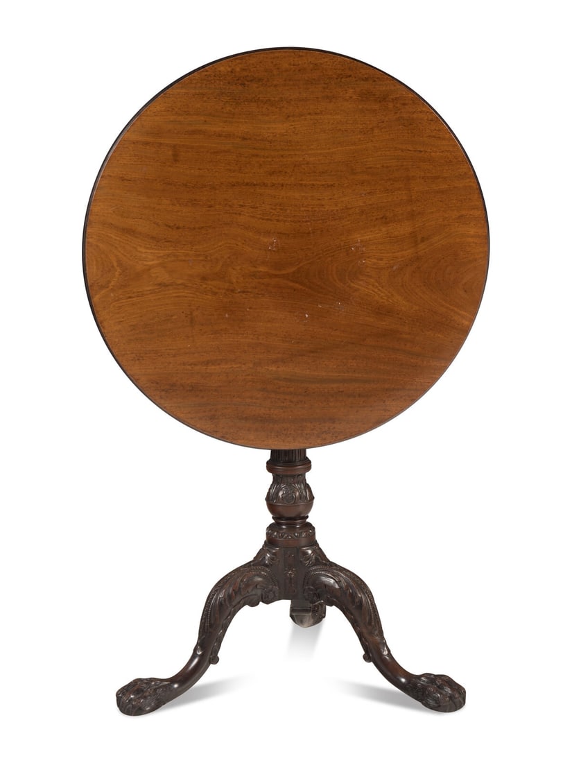 A George III Mahogany Tripod Table: A George III Mahogany Tripod Table Circa 1770 the birdcage mechanism surmounting a carved columnar stem, the legs carved with foliate caps and ending in hairy paw feet. Height 27 3/4 x diameter 26 inc