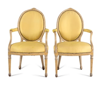 A Pair of George III Carved, Grey-Painted and Parcel Gilt Armchairs