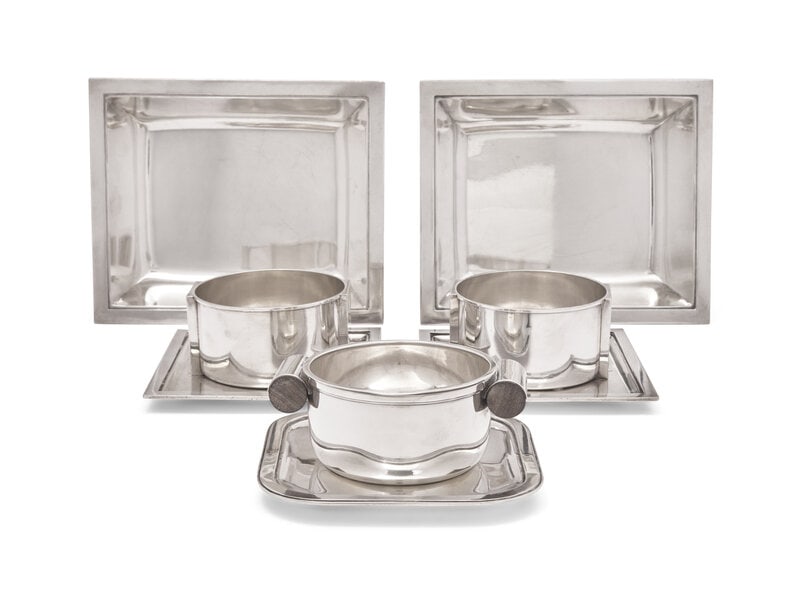 A Group of Puiforcat .950 Silver Table Articles: A Group of Puiforcat .950 Silver Table Articles France, 20th Century Comprising: A bottle coaster and liner with rosewood handles and attached undertray A pair of bottle coasters with attached u