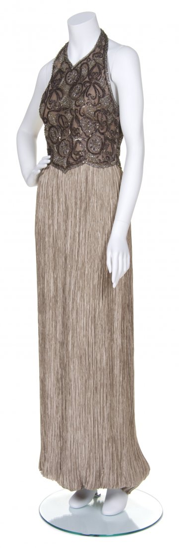 A Mary McFadden Champagne Marii Pleat Halter Evening Go: A Mary McFadden Champagne Marii Pleat Halter Evening Gown, with brown and gold beaded bodice. Labeled: Mary McFadden Couture. Size 6. Property of a Lady, Chicago, Illinois