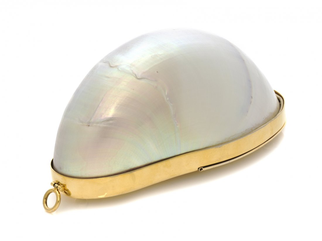 A Judith Leiber Mother of Pearl Half Shell Minaudiere, : A Judith Leiber Mother of Pearl Half Shell Minaudiere, with detachable gold chain shoulder strap, comes with comb and mirror. Stamped: Judith Leiber. 6 1/2 x 3 1/2 x 3 inches. Property of a Lady, Minn