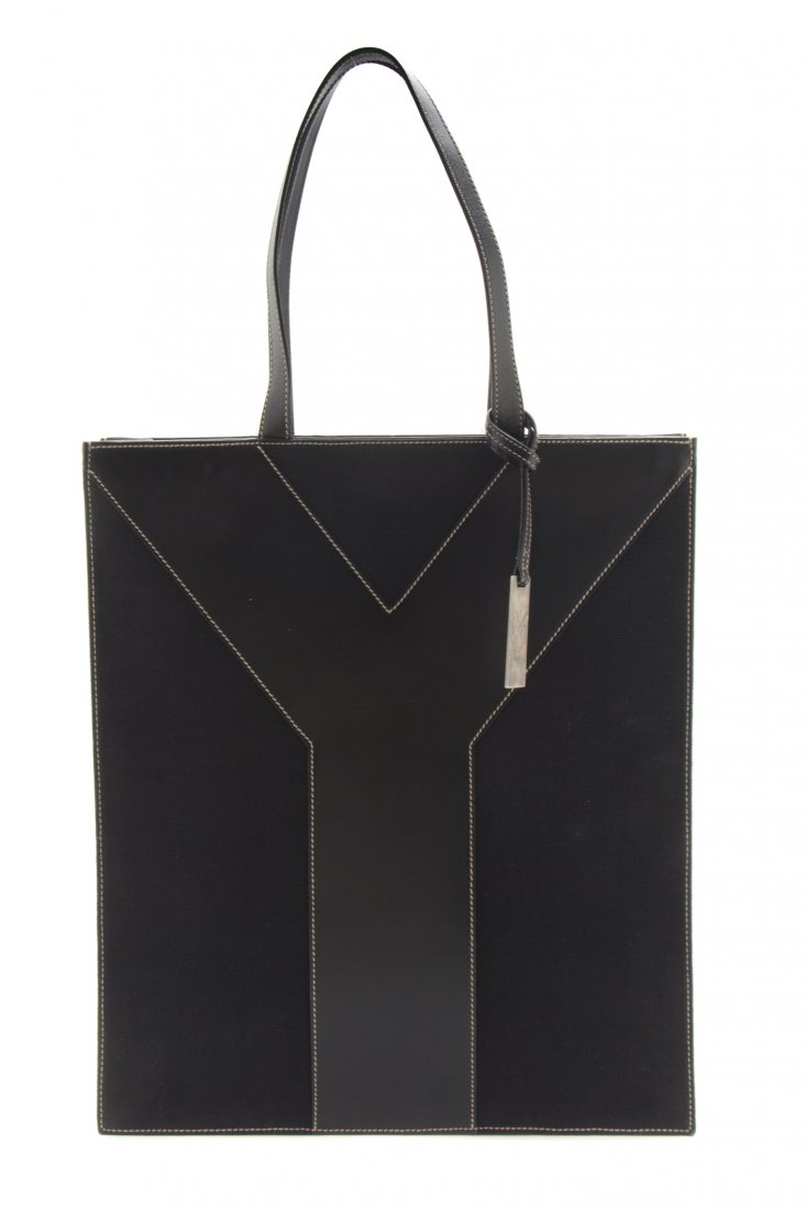 An Yves Saint Laurent Black Leather and Canvas Tote Bag: An Yves Saint Laurent Black Leather and Canvas Tote Bag, black leather Y on black canvas ground with contrast tan stitching, black leather lining. Stamped: Yves Saint Laurent. 16 1/2 x 14 1/2 x 3 inch