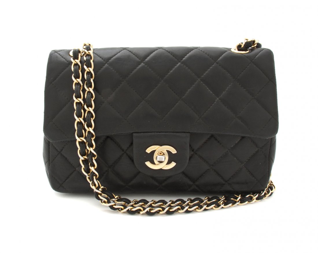 A Chanel Black Lambskin Bag, 9 x 5 x 2 1/2 inches.: A Chanel Black Lambskin Bag, goldtone chainlink and leather shoulder strap, exterior pocket on back side, flap closure, red leather lining. Stamped: Chanel. 9 x 5 x 2 1/2 inches.