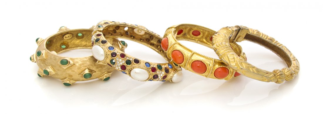A Group of Four Kenneth Jay Lane Bangles,: A Group of Four Kenneth Jay Lane Bangles, comprised of a textured goldtone and green cabochon hinged bangle stamped K.J.L., an unsigned faux pearl and multicolor rhinestone hinged bangle, a textured g