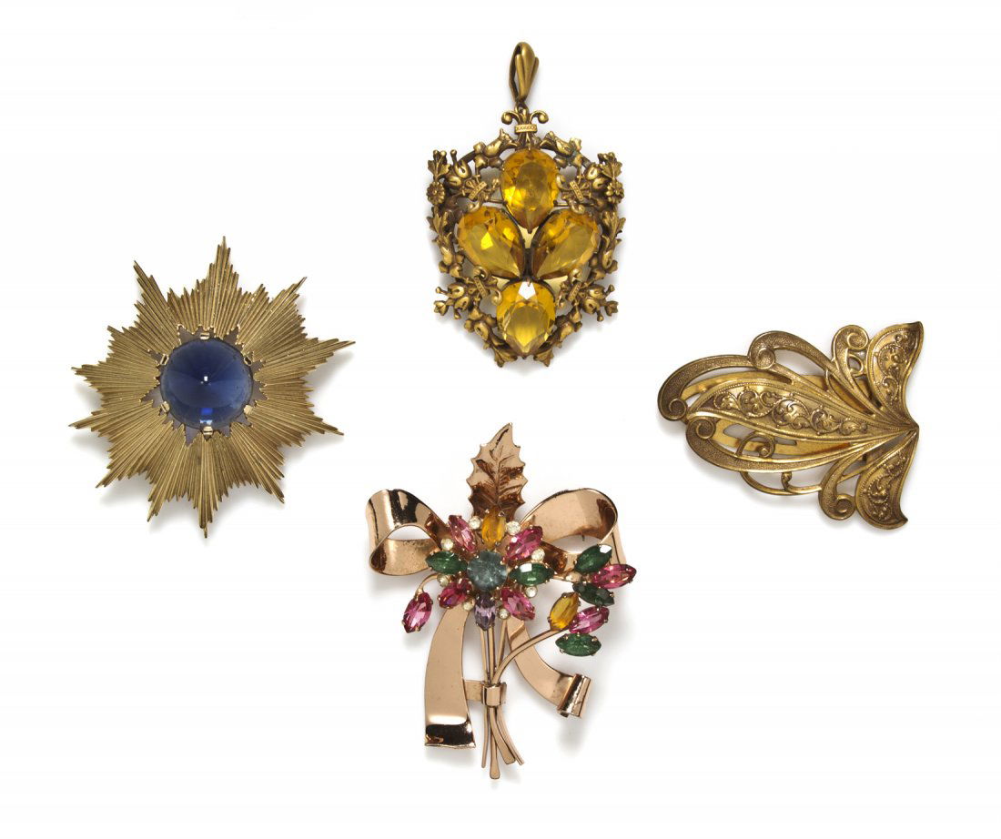 A Group of Four Brooches,: A Group of Four Brooches, comprised of Trifari goldtone and blue cabochon sunburst, a Joseff Hollywood goldtone dress clip, a Joseff Hollywood goldtone and yellow rhinestone shield, and a Coro Craft s