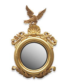 A Classical Carved and Giltwood Bull's Eye Mirror: A Classical Carved and Giltwood Bull's Eye Mirror Circa 1820 with carved leafage and shell, surmounted by eagle cartouche. 45 x 28 inches. This lot is located in Philadelphia.