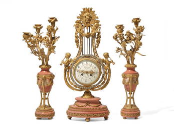 A Louis XVI Style Gilt Bronze and Pink Marble Three-Piece Clock Garniture