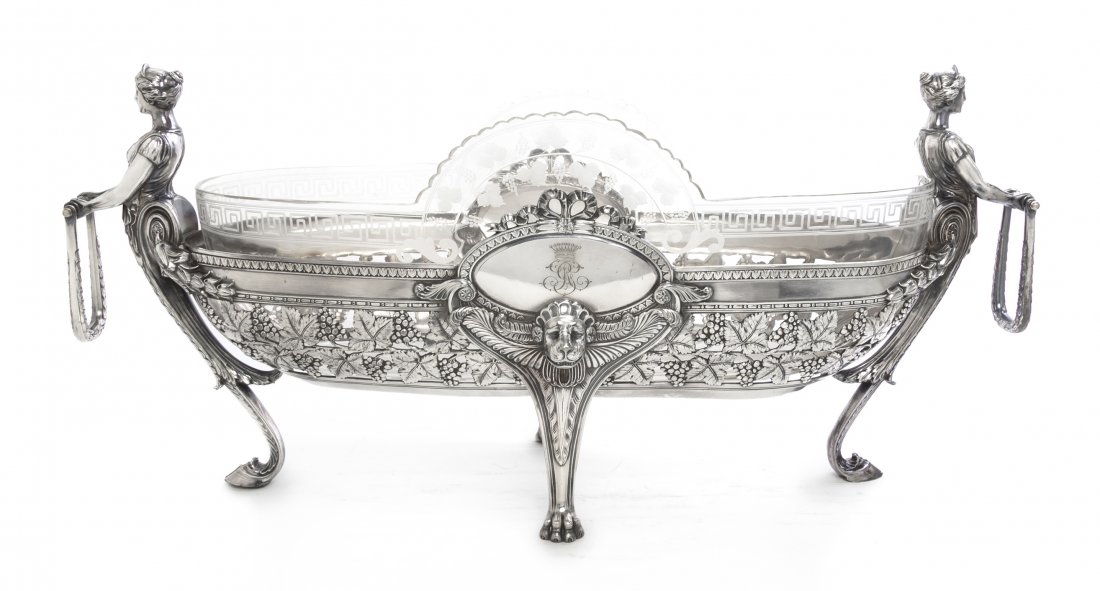 A Silverplate and Etched Glass Center Bowl, Width 25 in: A Silverplate and Etched Glass Center Bowl, the oval glass etched with Greek key and foliate decoration, set in a conforming stand with female form swing handles, further having lion mask and grapevin