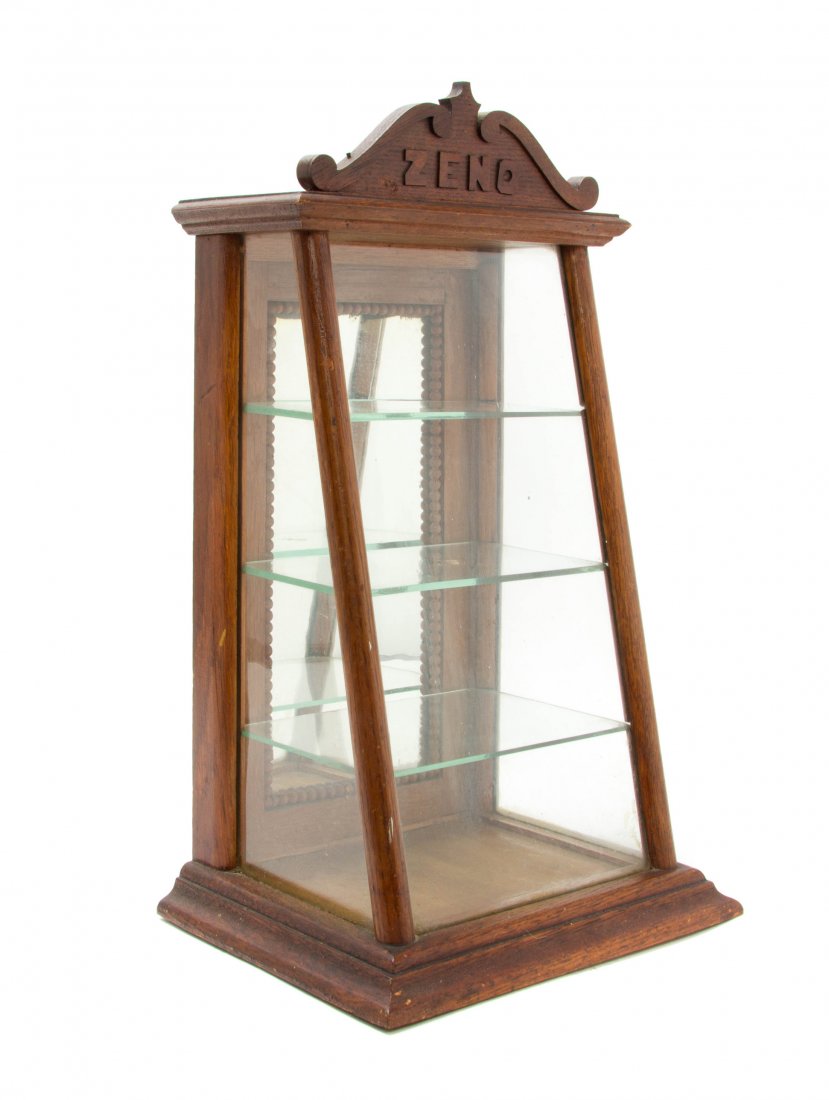 An American Zeno Gum Oak Countertop Display Case, Heigh: An American Zeno Gum Oak Countertop Display Case, Chicago, having an arched crest with the Zeno logo over the sloping glazed front, having a rear mirrored door opening to a shelved interior. Height 18