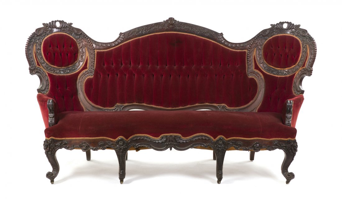 A Victorian Renaissance Revival Mahogany Triple-Back Se: A Victorian Renaissance Revival Mahogany Triple-Back Settee, having a scrolling, foliate carved crest rail over the upholstered back, arms and seat, raised on carved cabriole legs ending in casters. W