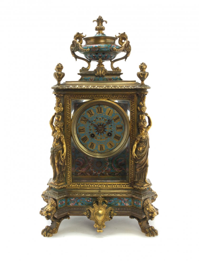 A French Gilt Bronze, Glass and Champleve Mantel Clock,: A French Gilt Bronze, Glass and Champleve Mantel Clock, surmounted by an urn with monoped griffin handles centering four flaming urn finials, the rectangular case with glazed sides inset with a circul