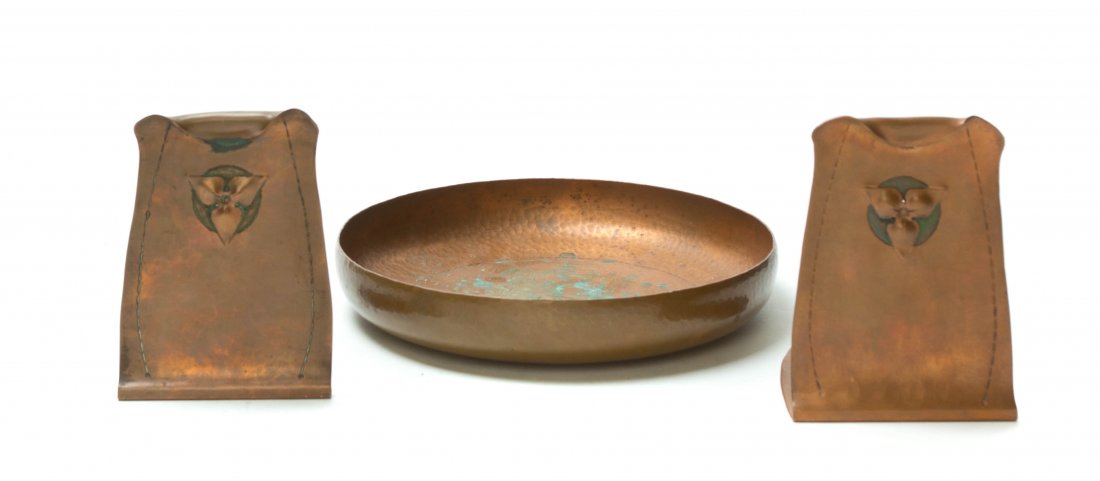 Three Roycroft Hammered Copper Articles, Diameter of bo: Three Roycroft Hammered Copper Articles, in the Trillium pattern, comprising a pair of bookends and a round bowl, each bearing an orb and cross mark. Diameter of bowl 8 3/8 inches.