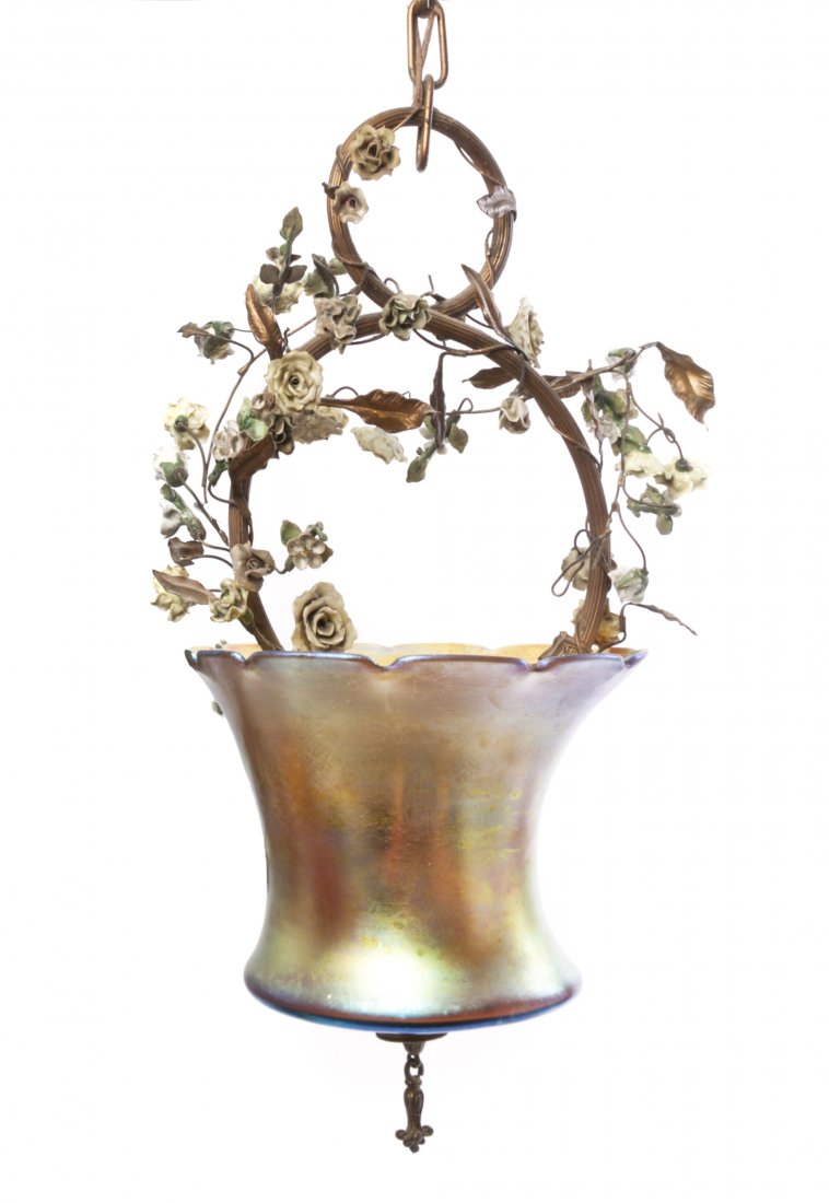 A Gilt Metal and Iridescent Glass Light Fixture, likely: A Gilt Metal and Iridescent Glass Light Fixture, likely Steuben, in the form of a basket with applied porcelain flowers. Height 21 inches. Property from the Dr. Myrna Salud Living Trust, Marion, India