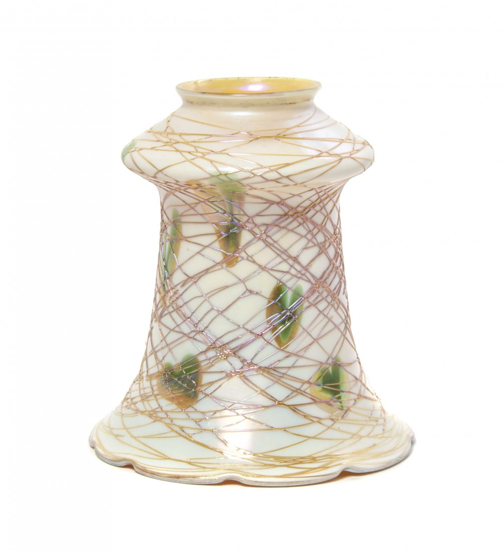A Quezal Iridescent Glass Shade, Height 5 5/8 inches.: A Quezal Iridescent Glass Shade, of fluted form with a scalloped rim, having heart and applied string decoration on a cream ground, the interior in gold iridescence. Height 5 5/8 inches.