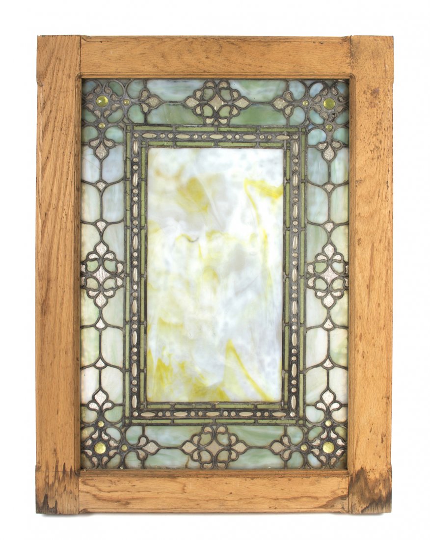 An American Leaded Opalescent Glass Window, in the mann: An American Leaded Opalescent Glass Window, in the manner of Tiffany Studios, having a rectangular center panel within a triple geometric border, further having a larger stylized geometric and jewel i