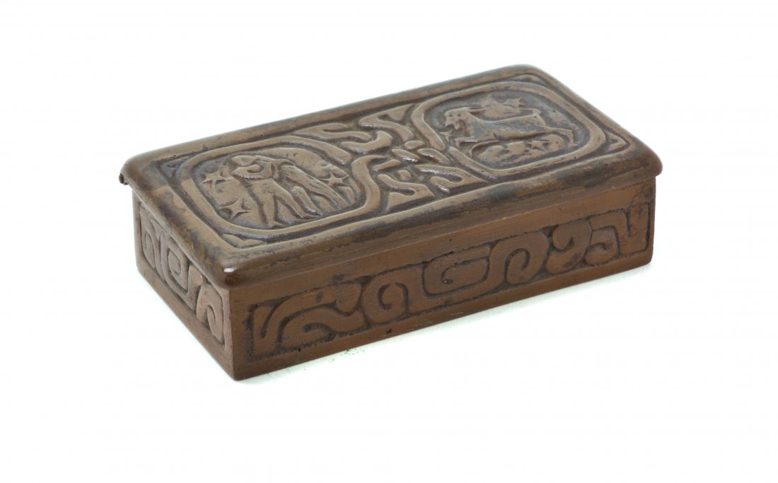 A Tiffany Studios Patinated Bronze Stamp Box, Width 3 3: A Tiffany Studios Patinated Bronze Stamp Box, in the Zodiac pattern, stamped Tiffany Studios, New York, 802. Width 3 3/4 inches.
