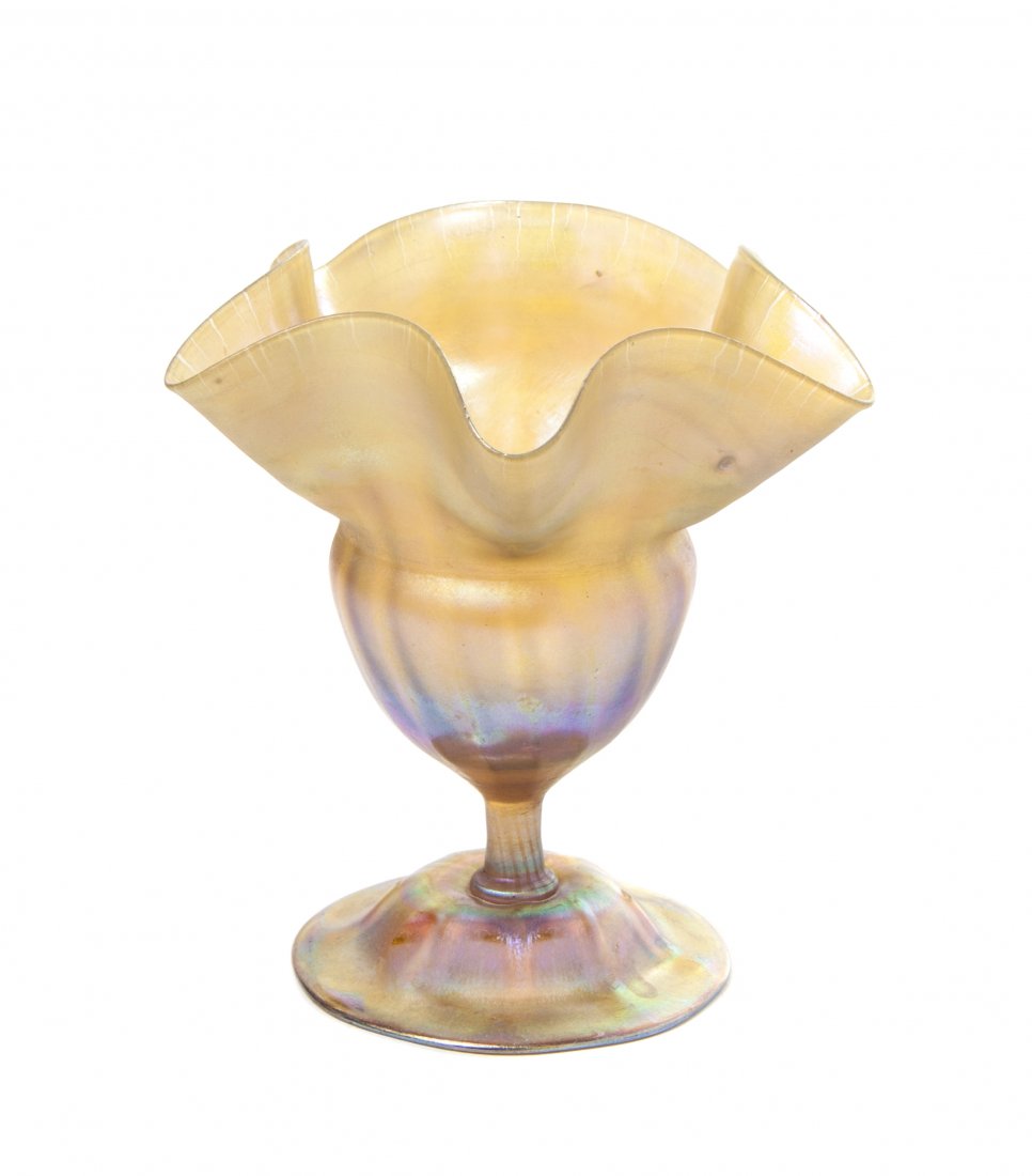 A Tiffany Studios Gold Favrile Glass Floriform Vase, He: A Tiffany Studios Gold Favrile Glass Floriform Vase, with a ruffled rim and bulbous bowl, raised on a circular foot, signed L.C.T. W8127. Height 5 inches.