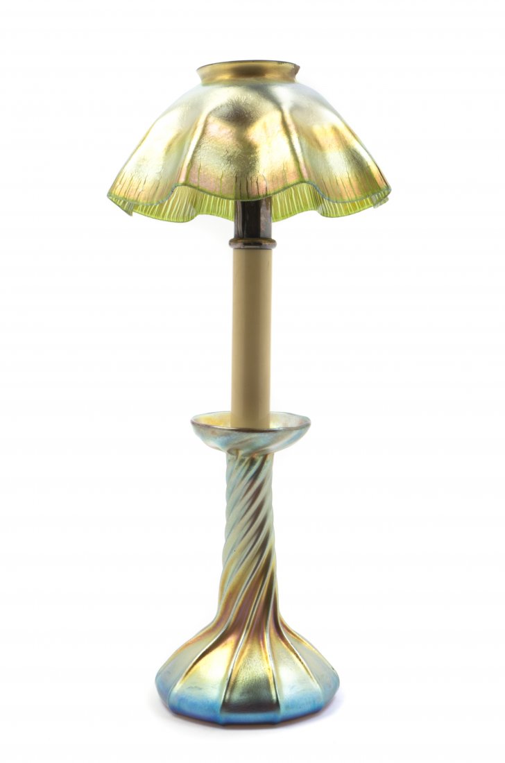 A Tiffany Studios Favrile Glass Candlestick Lamp, Heigh: A Tiffany Studios Favrile Glass Candlestick Lamp, the glass shade of crackled ruffled form, in gold iridescence, over the silvered and composite insert, raised on a twisted base, in blue iridescence, 