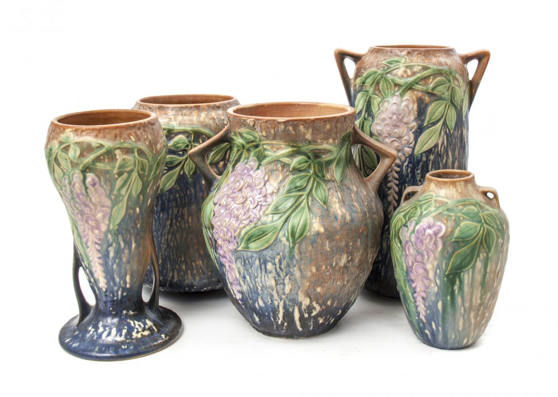 Five Roseville Pottery Vases, Height of tallest 10 3/8 : Five Roseville Pottery Vases, each in the Wisteria pattern, of handled form with a blue ground, one with the original foil label. Height of tallest 10 3/8 inches. Property from the Estate of Ms. Jacqu