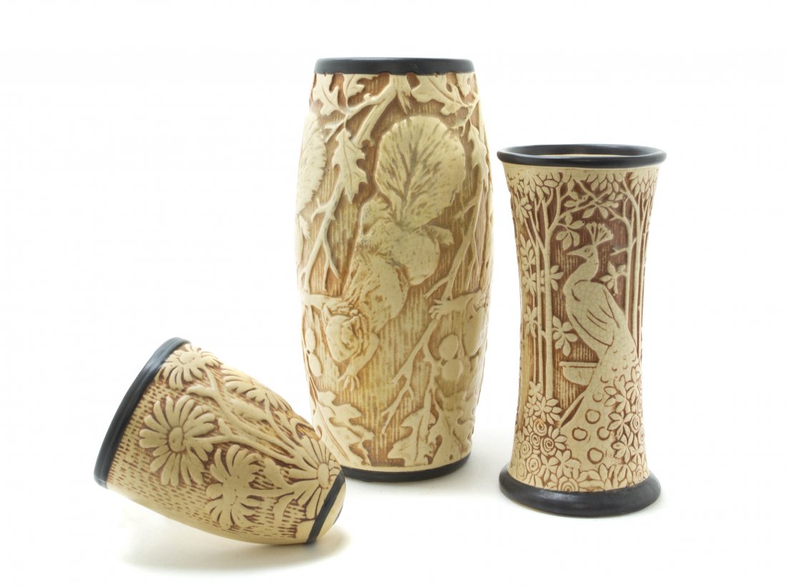 Three Weller Pottery Articles, Height of tallest 11 1/4: Three Weller Pottery Articles, each in the Knifewood pattern, comprising a vase of barrel form, decorated with a flying squirrel, a vase of waisted form decorated with a peacock and a wall pocket. Hei