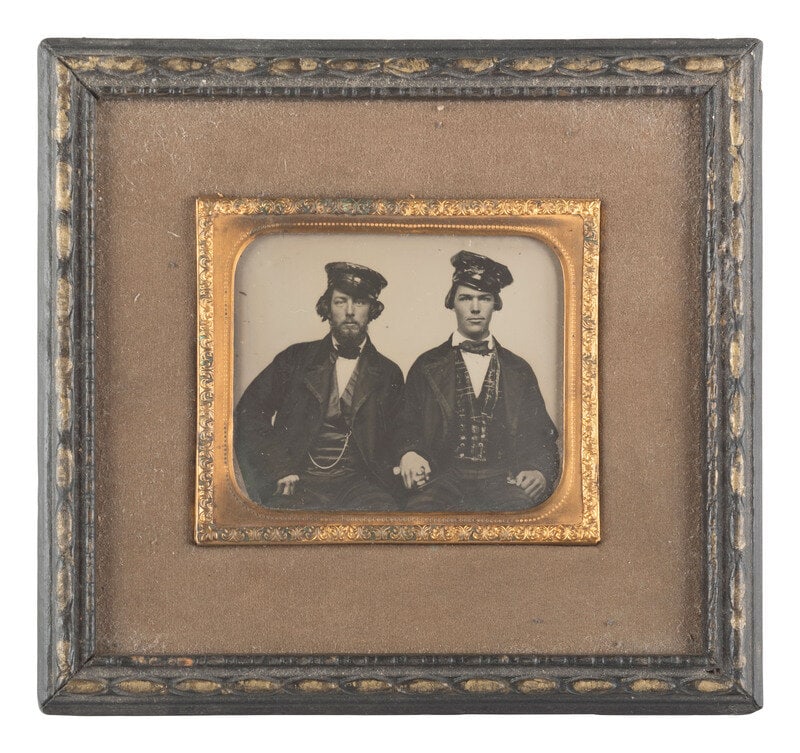 [EARLY PHOTOGRAPHY]. Occupational ambrotype of two men holding hands, possibly railroad conductors. (1 of 1)