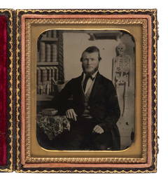 [EARLY PHOTOGRAPHY]. Sixth plate ambrotype of a young doctor with skeleton in painted background. 