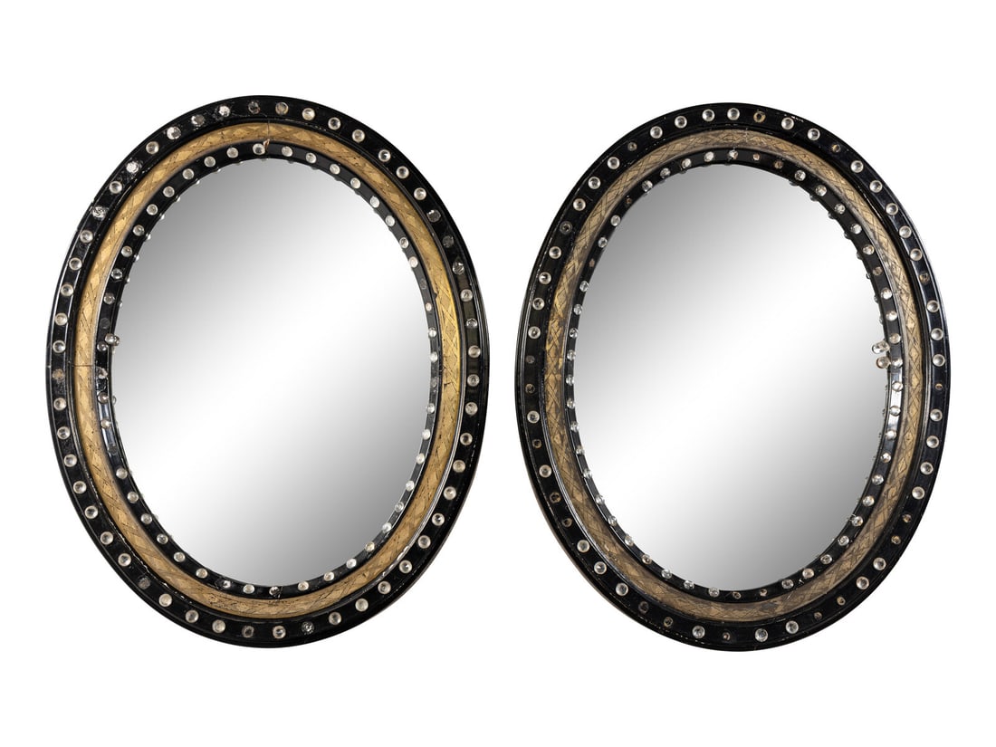 A Pair of Irish Ebonized and Parcel-Gilt Oval Mirrors: A Pair of Irish Ebonized and Parcel-Gilt Oval Mirrors 19th Century Height 28 1/2 x width 22 inches. Property from Camp Rosemary, the Estate of Posy Krehbiel, Lake Forest, Illinois This lot is located