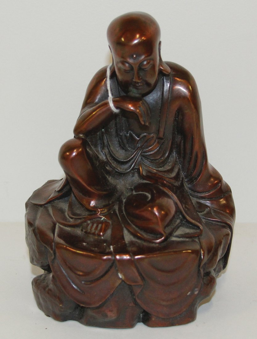 A Chinese Bronze Figure of a Luohan, Height 7 12 inches: A Chinese Bronze Figure of a Luohan, depicted seated in draped robes on a naturalistic base. Height 7 12 inches.