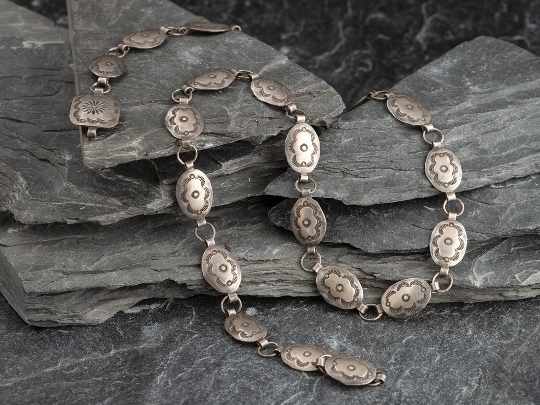 Petite Navajo Stamped Silver Link Concha Belt: Petite Navajo Stamped Silver Link Concha Belt second quarter - mid 20th century twenty-one conchas and matching buckle; not marked concha height 5/8 inch x width 1 inch, buckle height 13/16 inch x wid