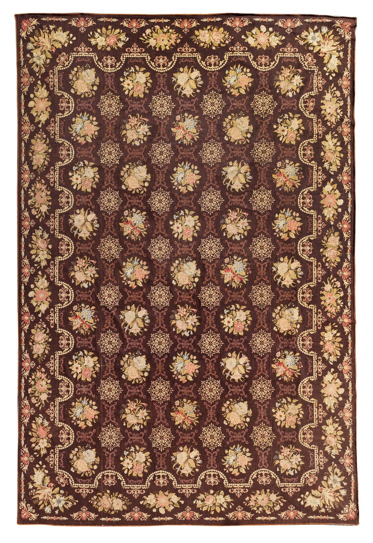 An English Needlepoint Wool Carpet: An English Needlepoint Wool Carpet 19th Century decorated with flowers and swags against a dark brown ground; muslin-backed. 11 feet 6 inches x 18 feet. This lot is located in Palm Beach.