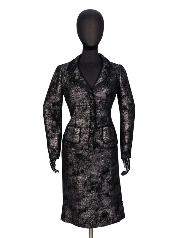 Prada, Silver-Coated Tweed Skirt Suit: Prada, Silver-Coated Tweed Skirt Suit JACKET Fitted jacket in black wool tweed with a metallic silver paint coating throughout. Notched lapels with ruffled black satin trim at edges. Wrist-len
