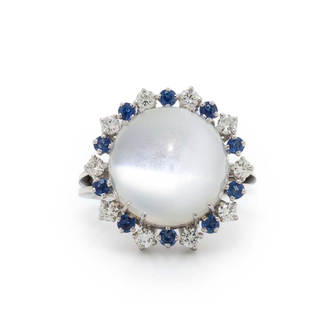 CAT'S EYE MOONSTONE, DIAMOND, AND SAPPHIRE RING: CAT'S EYE MOONSTONE, DIAMOND, AND SAPPHIRE RING Round cabochon cat's eye moonstone, round sapphires, and round diamonds. White gold. Ring size 7 1/2. Gross weight: 5.75 dwt. This lot is located in Chi