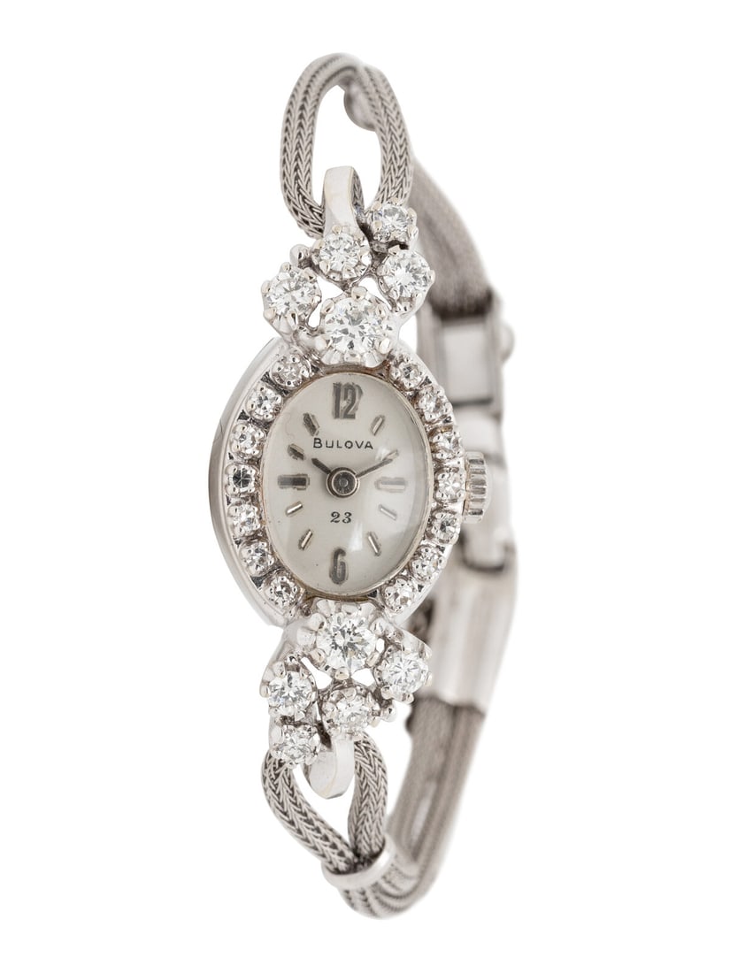 BULOVA, 14K WHITE GOLD AND DIAMOND DRESS WATCH: BULOVA, 14K WHITE GOLD AND DIAMOND DRESS WATCH Maker: Bulova Serial number: 412478 Case size: Approx. 14 x 16 mm Case material: 14K white gold Bezel: Diamonds Dial: White Movement: Quartz Bracelet/Str