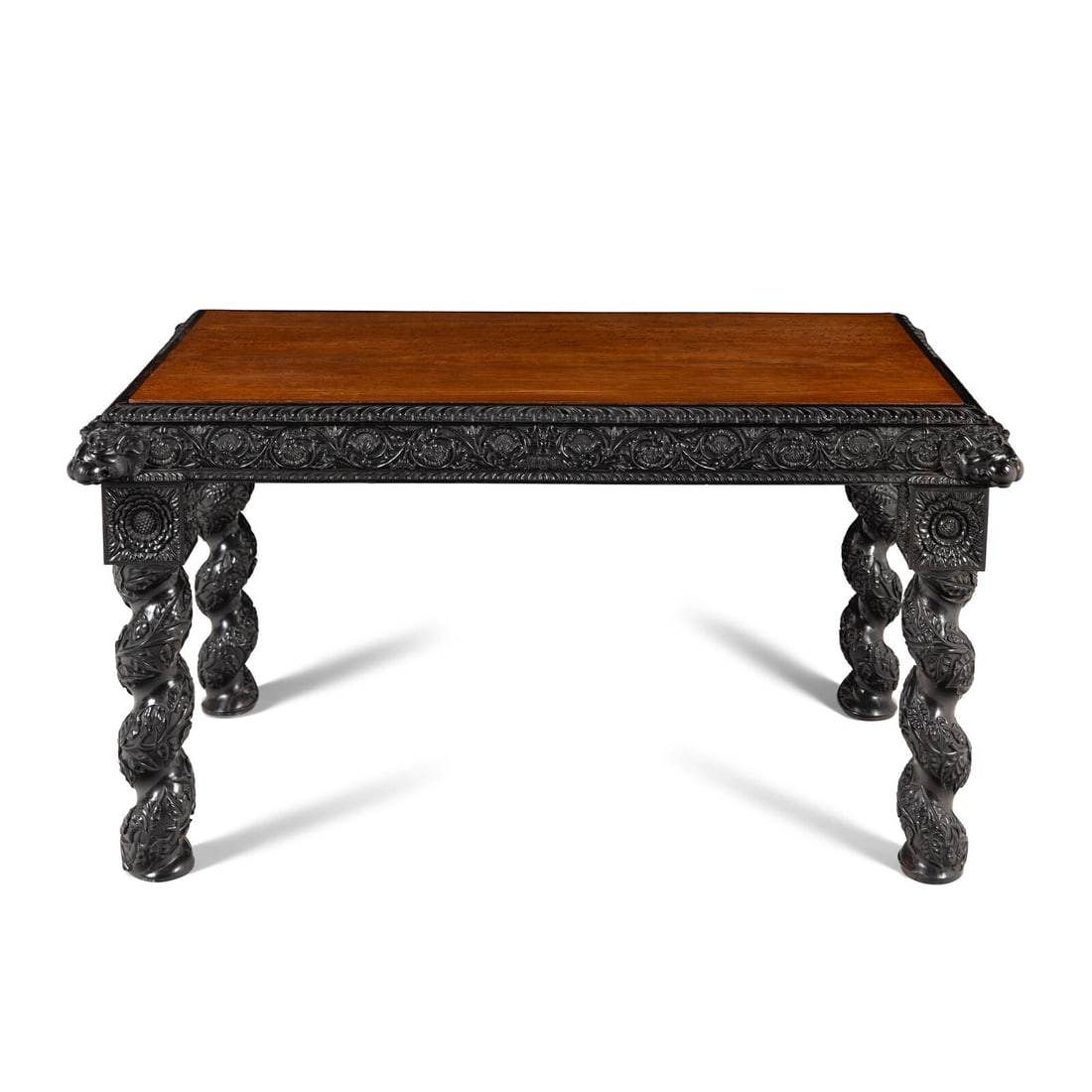 An Anglo-Colonial Carved Ebony and Satinwood Center Table: An Anglo-Colonial Carved Ebony and Satinwood Center Table Probably Ceylonese, Mid-19th Century Height 30 1/4 x width 57 x depth 34 1/2 inches. Property of a Main Line Gentleman, Pennsylvania This lot