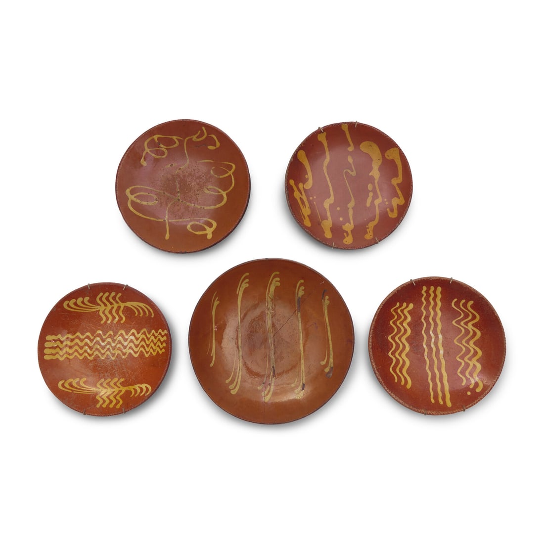 A Group of Five Slip-Decorated Redware Plates: A Group of Five Slip-Decorated Redware Plates Pennsylvania, 19th Century Diameter 13 1/8 inches (largest). This lot is located in Philadelphia.