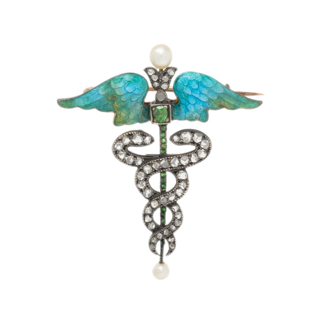 ART NOUVEAU, DIAMOND, SEED PEARL, DEMANTOID GARNET, AND ENAMEL CADUCEUS BROOCH: ART NOUVEAU, DIAMOND, SEED PEARL, DEMANTOID GARNET, AND ENAMEL CADUCEUS BROOCH Rose cut diamonds, round and oval demantoid garnets, seed pearls, and enamel. Silver-topped yellow gold and silver. 1 1/2