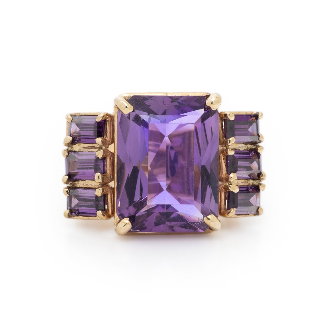 AMETHYST AND YELLOW GOLD RING: AMETHYST AND YELLOW GOLD RING Modified rectangular step cut amethyst measuring approximately 14.95 x 11.20 x 7.10 mm and baguette cut amethysts. 14 karat yellow gold. Ring size 5 1/2. Stamp: 14K.