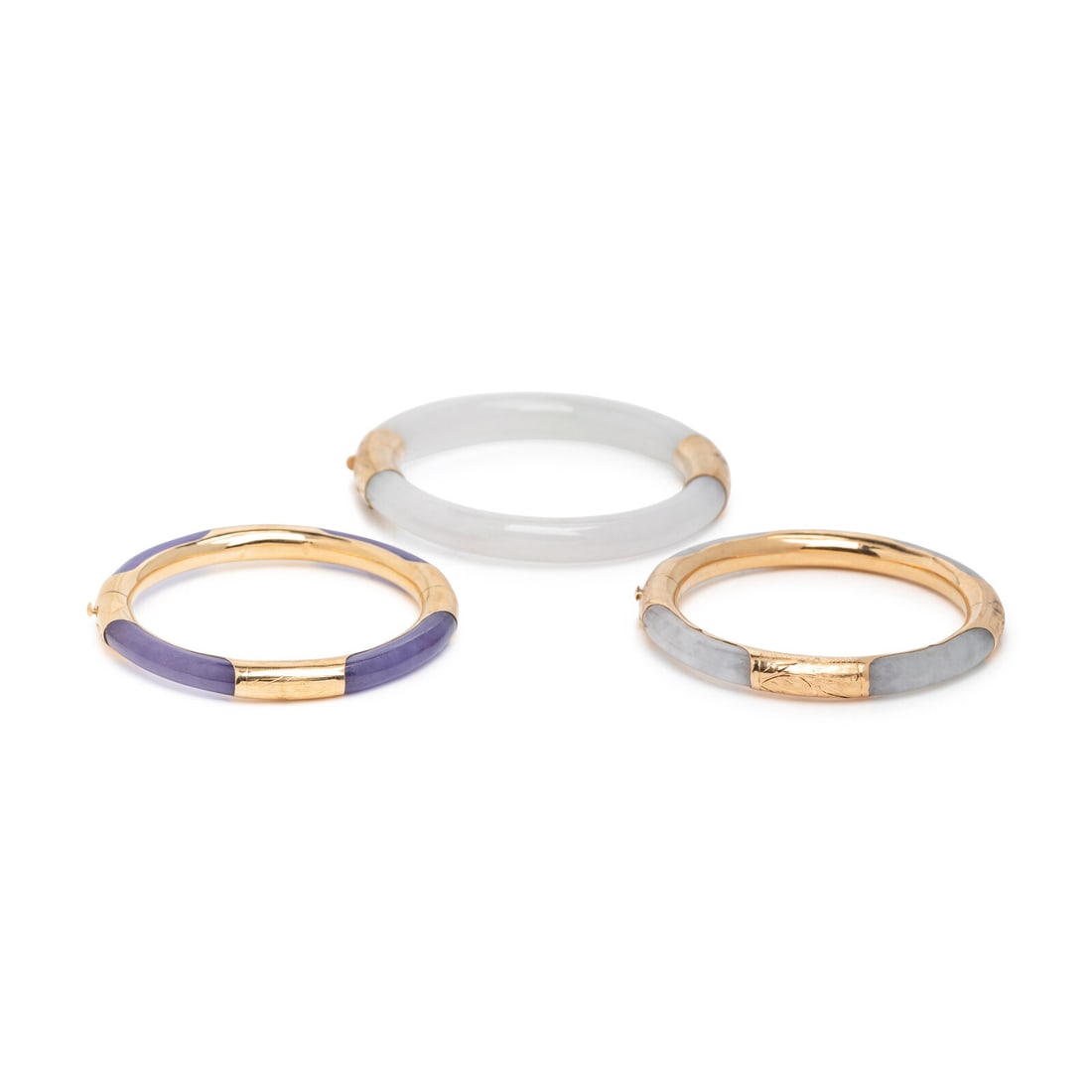 THREE JADE AND YELLOW GOLD BANGLE BRACELETS: THREE JADE AND YELLOW GOLD BANGLE BRACELETS Including three jade bangle bracelets, all hinged with side clasps. 14 karat yellow gold. 6 3/4, 6 3/4, and 7 3/8 inches inner circumference. Stamp: 14K 585