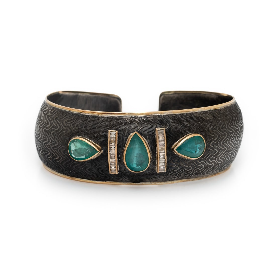 EMERALD, DIAMOND, SILVER, AND YELLOW GOLD CUFF BRACELET: EMERALD, DIAMOND, SILVER, AND YELLOW GOLD CUFF BRACELET Pear shape emeralds weighing approximately 6.10 carats total by formula and baguette cut brown diamonds (origin of color not tested). Silver and