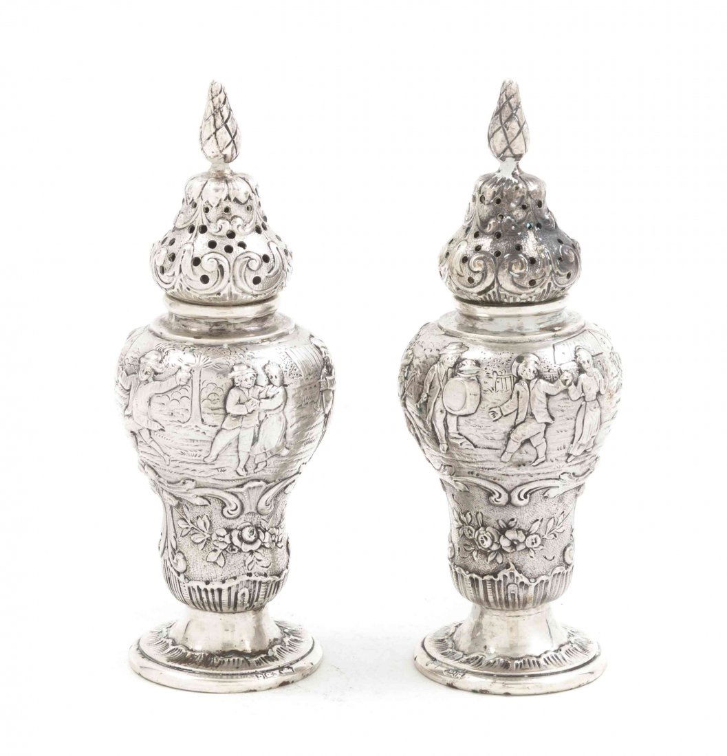 Two German Silver Casters, Georg Roth & Co., Height 4 3: Two German Silver Casters, Georg Roth & Co., Hanau, each of baluster form, decorated with repousse figural scenes, together with a continental silver coaster; approximate total weight 8.25 ozt. Height