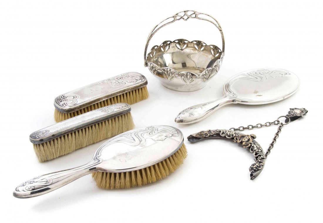 A German Art Nouveau Silverplate Dresser Set, WMF, Leng: A German Art Nouveau Silverplate Dresser Set, WMF, comprising a hand mirror and three brushes, together with a handled basket by WMF and a coin purse mount with a belt hook and chain marked German Sil