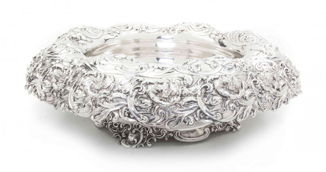 An American Sterling Silver Center Bowl, Mauser Manufac: An American Sterling Silver Center Bowl, Mauser Manufacturing Co., of low form having a shaped border with pierced foliate repousse decoration; approximate weight 110.74 ozt. Diameter 18 inches.