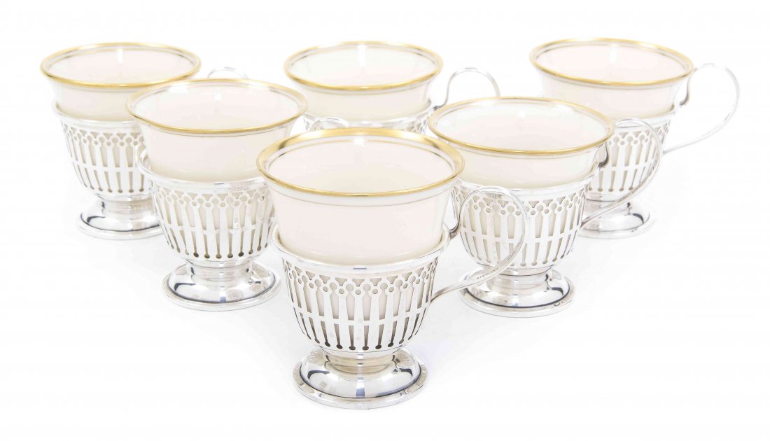 A Set of Twelve American Sterling Silver Teacup Holders: A Set of Twelve American Sterling Silver Teacup Holders, Mauser Manufacturing Co., having reticulated decoration and reeded handles, with Lenox liners; approximate total weighable 8.12 ozt. Height ove