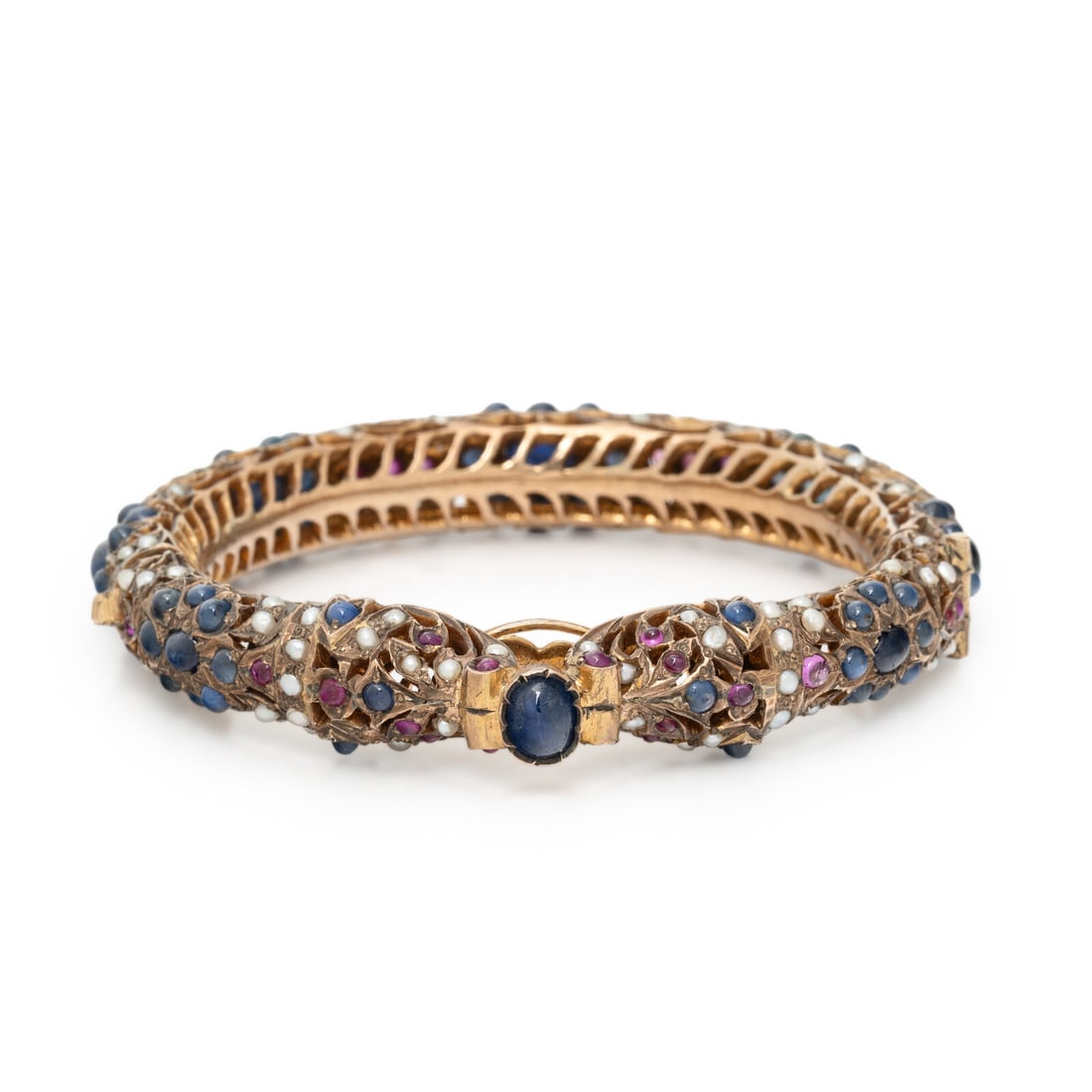 MUGHAL, SAPPHIRE, RUBY, AND SEED PEARL BRACELET: MUGHAL, SAPPHIRE, RUBY, AND SEED PEARL BRACELET Oval and round cabochon sapphires, round cabochon rubies, and seed pearls, hinged with side clasp. Low-karat yellow gold. 6 1/2 inches inner circumferen