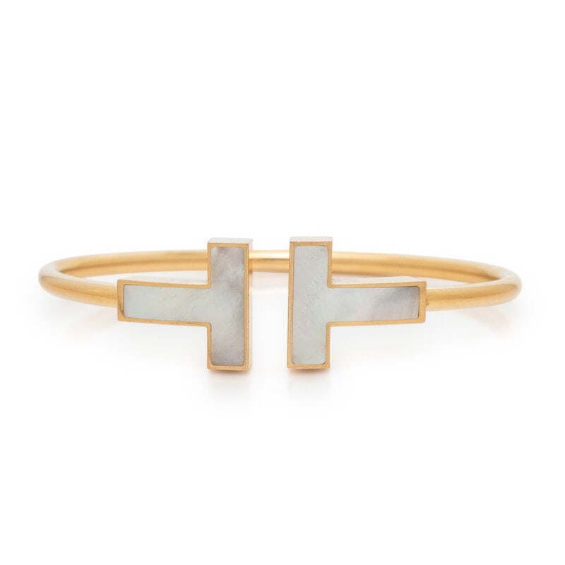 TIFFANY & CO., MOTHER-OF-PEARL AND YELLOW GOLD 'T' WIRE CUFF BRACELET: TIFFANY & CO., MOTHER-OF-PEARL AND YELLOW GOLD 'T' WIRE CUFF BRACELET Mother-of-pearl, semi-flexible. 18 karat yellow gold. 6 inches inner circumference. Stamp: © T & Co. Au750 ITALY. Gro