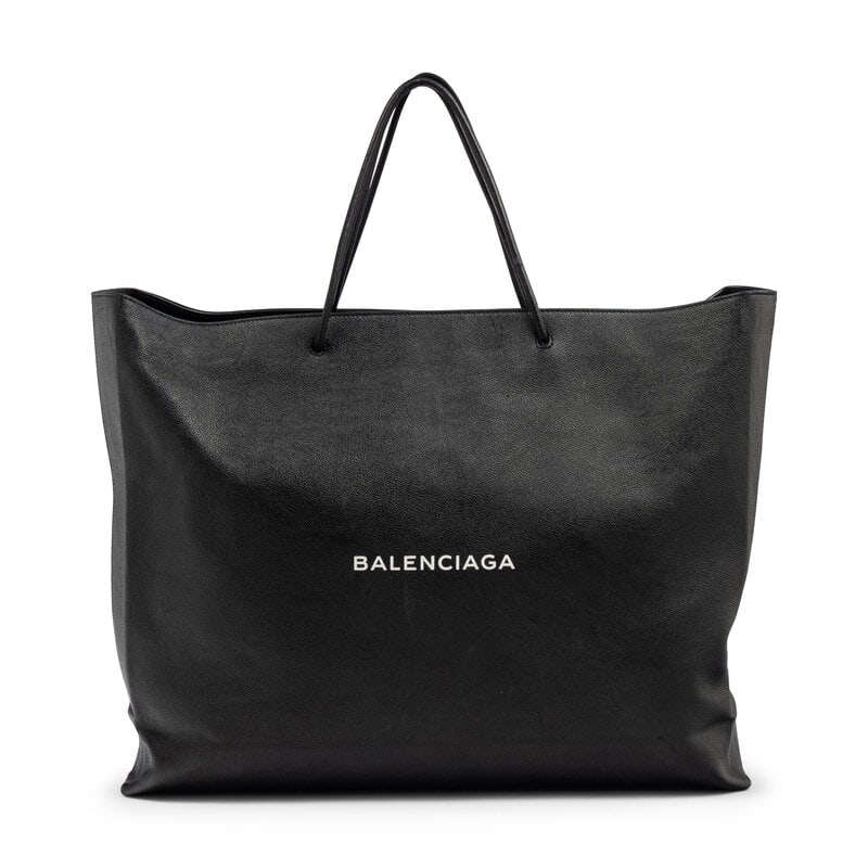 BALENCIAGA, XL LEATHER LOGO SHOPPING TOTE: BALENCIAGA, XL LEATHER LOGO SHOPPING TOTE XL Shopping Tote bag in black grained leather with a white printed logo at front. Double ended zipper closure and rolled leather handles. Label: