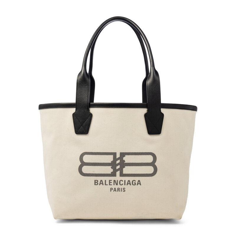 BALENCIAGA, WHITE CANVAS LOGO TOTE: BALENCIAGA, WHITE CANVAS LOGO TOTE Shopper tote bag in white canvas with a grey logo print and black leather trim. Open top and rolled leather straps. Label: Balenciaga Style/Serial No.: