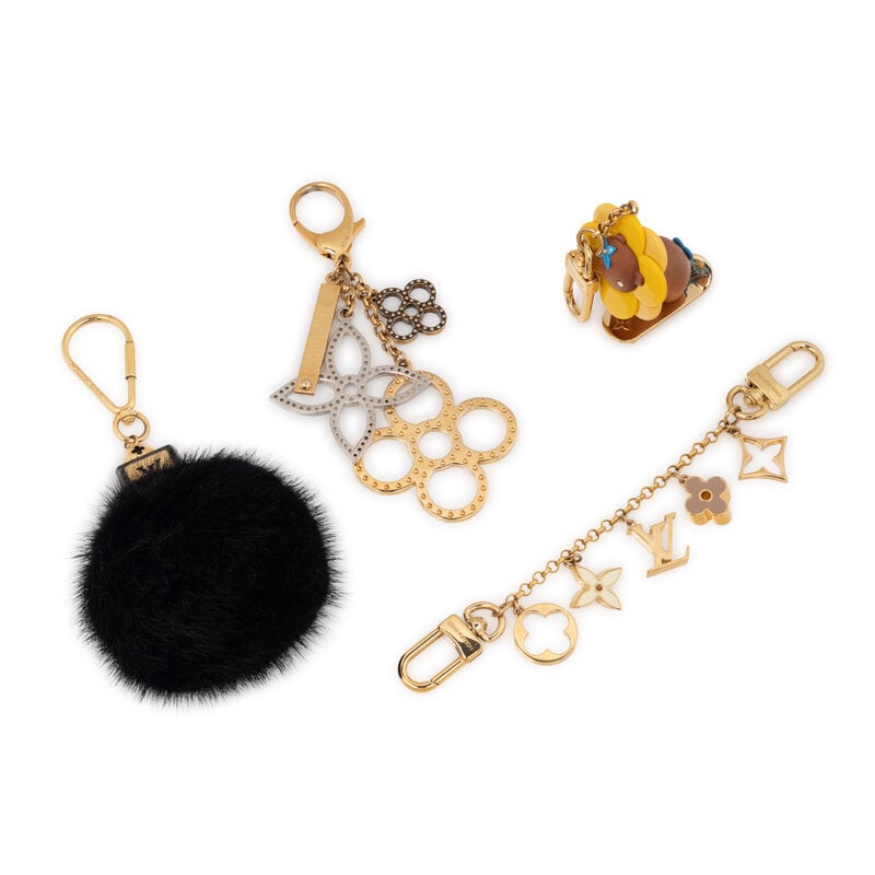 LOUIS VUITTON, GROUP OF FOUR BAG CHARMS: LOUIS VUITTON, GROUP OF FOUR BAG CHARMS THE FIRST Fluffy bag charm in black mink fur with gold-tone hardware. Label: Louis Vuitton Country of Origin: Italy Approximate Measurements: 7“ L x